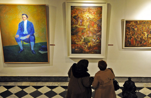 Visitantes de museos viendo cuadros