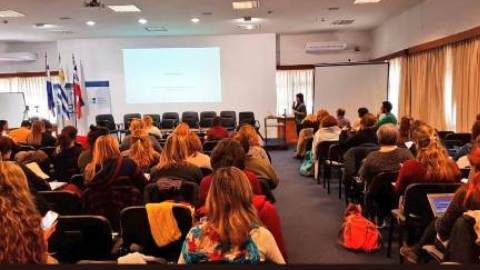 personas sentadas espacio auditorio mujer hablando con micrófono